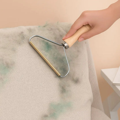 Brosse épilateur anti-poils avec manche en bois utilisée pour enlever les poils d’animaux sur un tissu